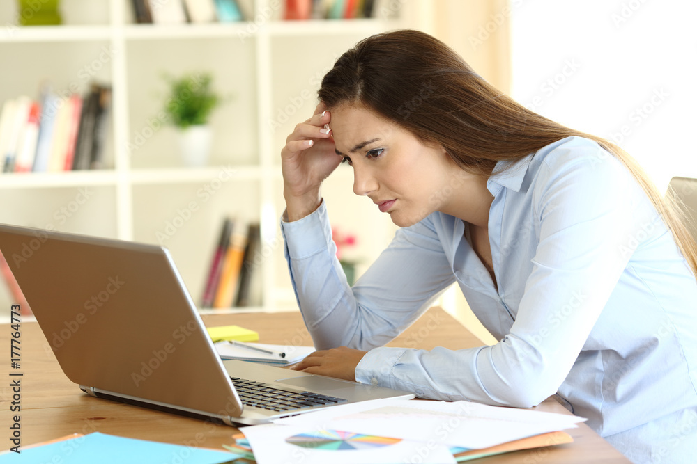 Worried freelance worker reading bad news on line Worried freelance worker reading bad news on line