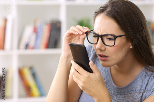 Girl with eyesight problems trying to read phone text photo