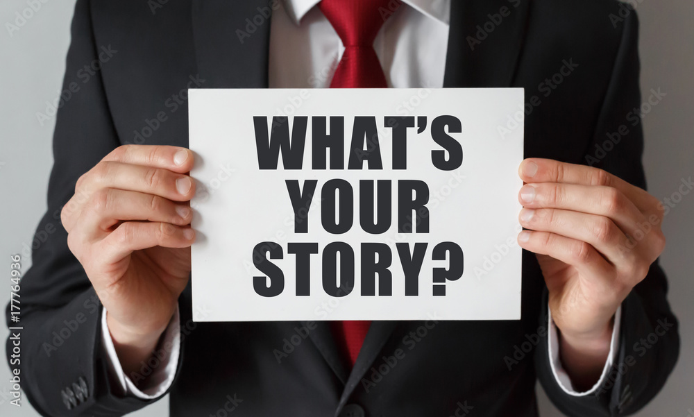 Businessman holding a card with text What's Your Story Businessman holding a card with text What's Your Story