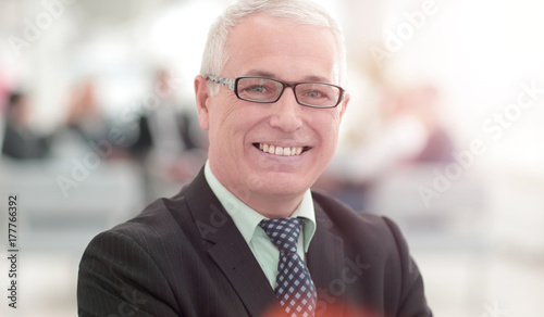 Mature friendly white-haired businessman in a modern office