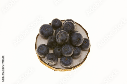 Blueberries on a wooden plate on a white background closeup.Background for confectionery, cafe fresh berries for pastry.