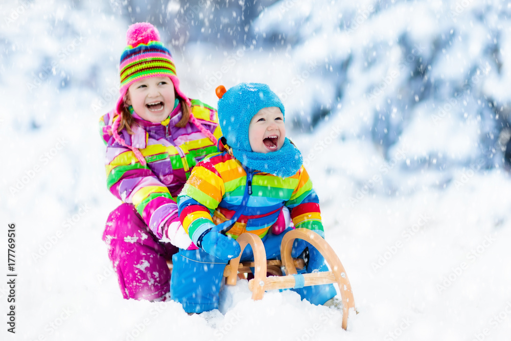 Kids on sleigh ride. Children sledding. Winter snow fun.