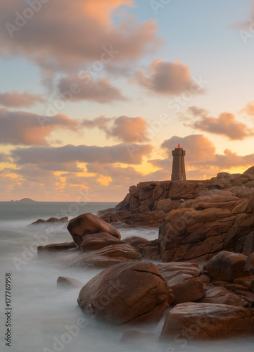 The beautiful lighthouse Phare Mean Ruz on the cote granite rose coast in Ploumanch, Brittany photo
