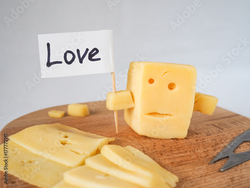 Funny cheese resembling the face holding with screen LOVE. photo