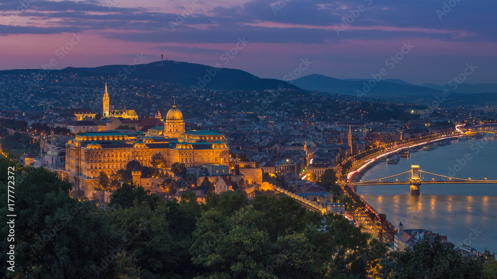 Naklejka premium Budapest, Hungary - Colorful sunset at magic hour over Budapest with Buda Castle Royal Palace and famous Szechenyi Chain Bridge