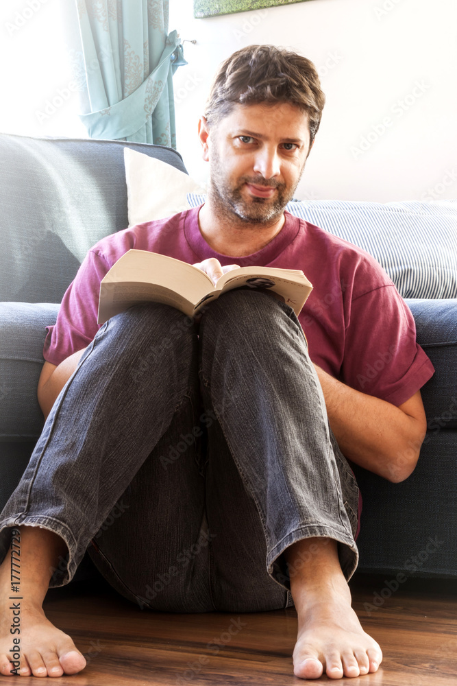 Fototapeta premium Young man reading a book