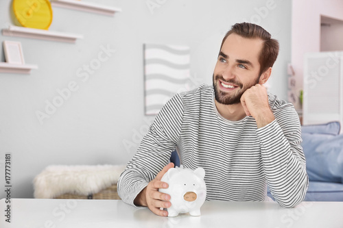 Young man with piggy bank a...