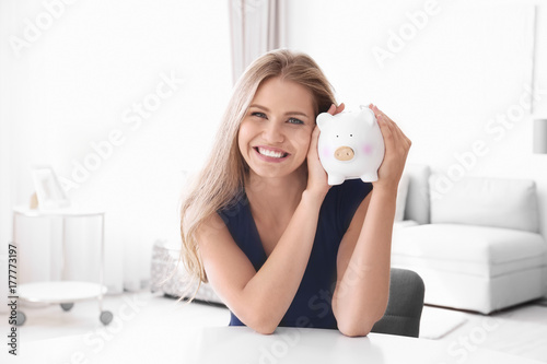 Young woman with piggy bank...