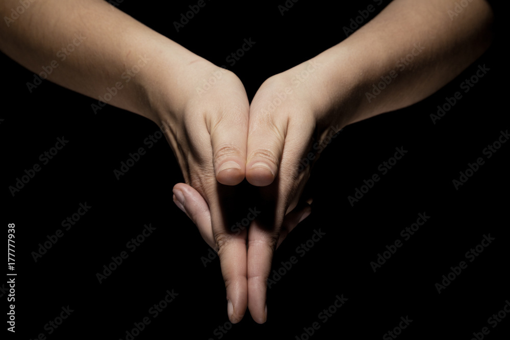 hands in mudra gesture on black background