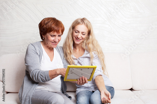 Mother with daughter looking at photo frame