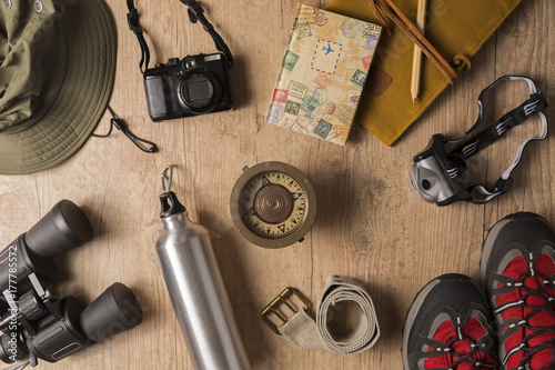 Overhead view of travel equipment for a backpacking trip on wooden floor. Adventure travel concept.