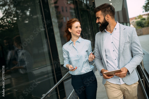Young business couple walking outdoor near office building