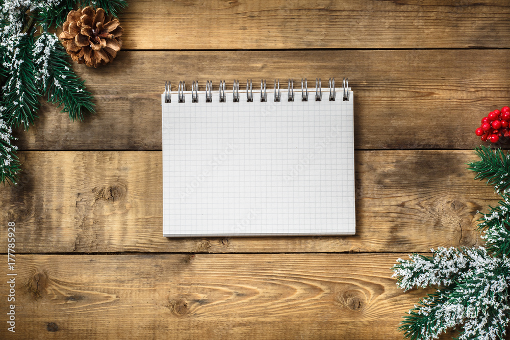 Blank paper notebook on brown wooden table background. Top view with copy space.