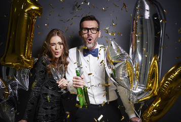 Friends dancing and drinking alcohol at new year celebration