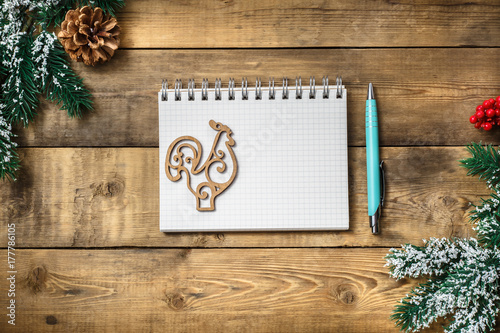 Blank paper notebook on brown wooden table background. Top view with copy space.