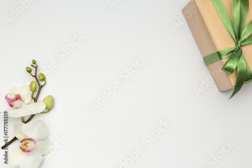 Gift box with orchid flower on white background
