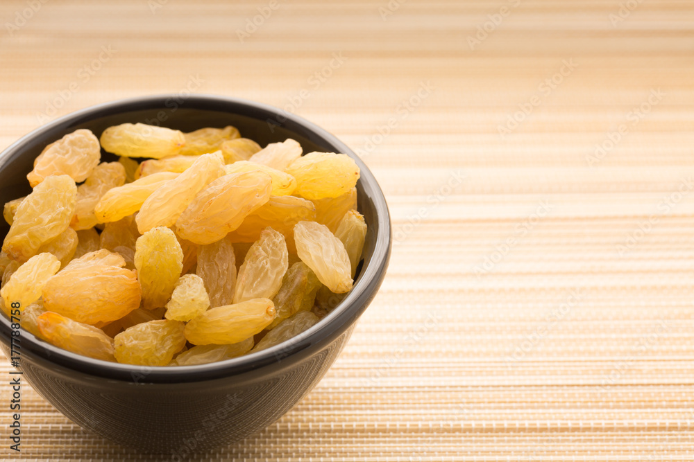 Healthy diet food white raisins full of natural vitamins in cup on bright light background Healthy diet food white raisins full of natural vitamins in cup on bright light background