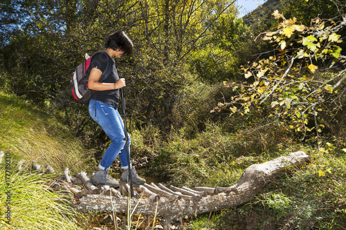 trekking and hiking , woman in wooden bridge over  river photo
