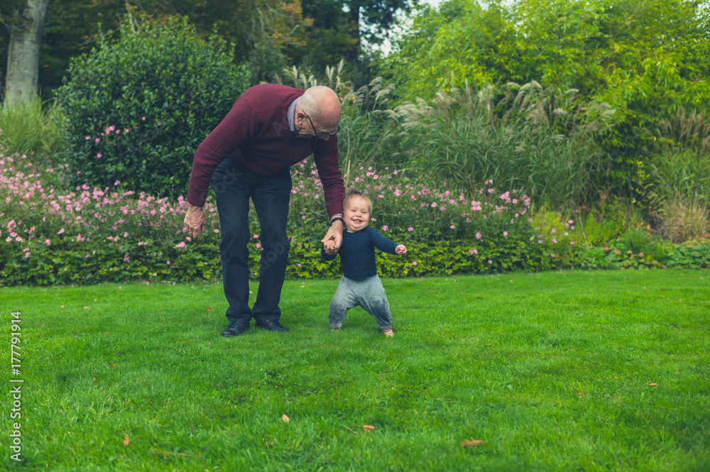 Obraz premium Grandfather running with grandson on lawn