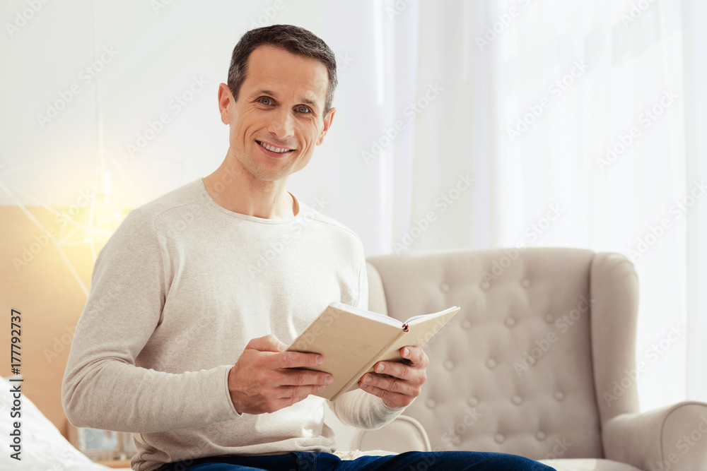 Positive delighted male holding notebook Positive delighted male holding notebook