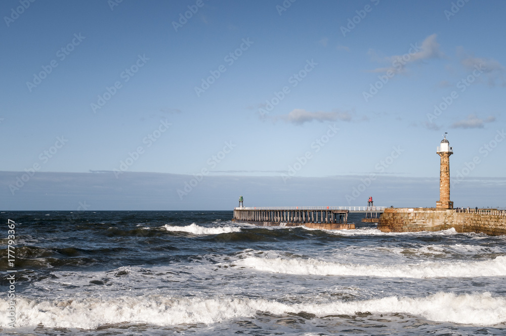Whitby Harbour West Pier with heavy seas comming in, Yorkshire, England