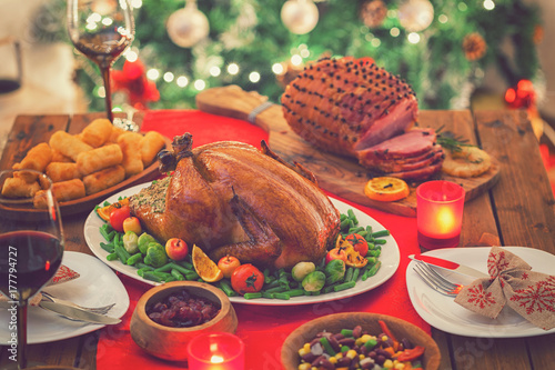 Fotografi Stuffed Christmas turkey dinner served in front of a Christmas tree