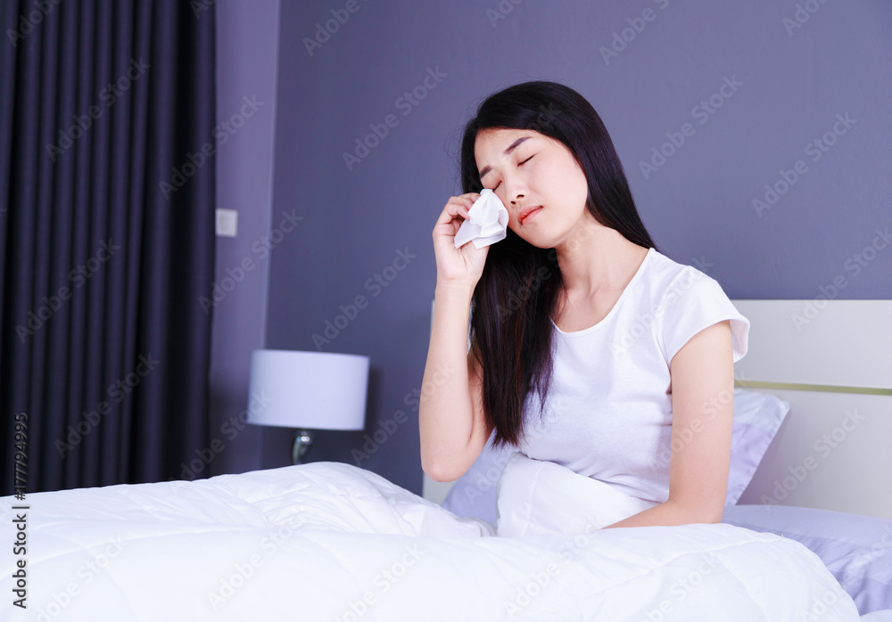 woman is crying on bed in bedroom woman is crying on bed in bedroom
