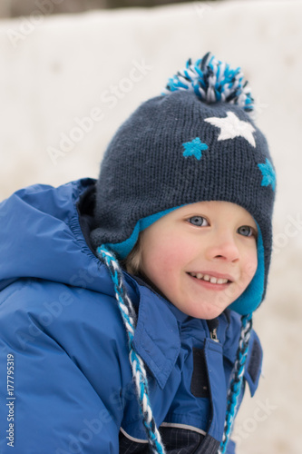 Happy boy lying in a snow - winter leisure for children