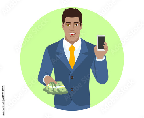 Businessman with money holding mobile phone