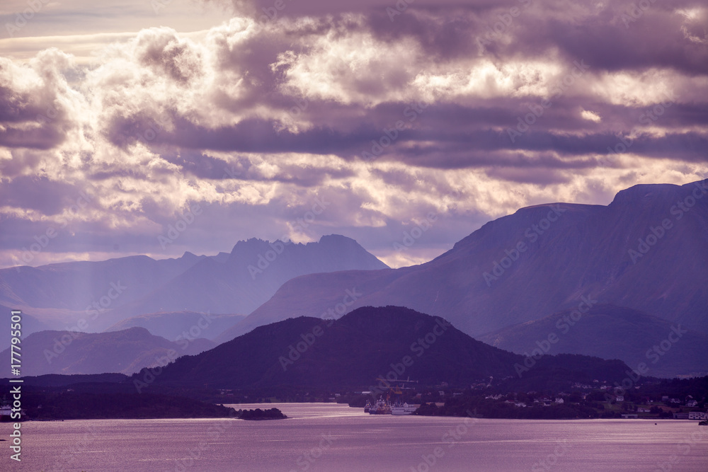 Rocky seashore. Mountain top outlined with cloudy sky. Wilderness. Beautiful nature Norway. Lofoten islands