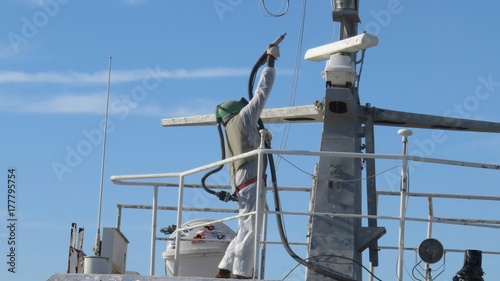 sandblaster at work on ship photo