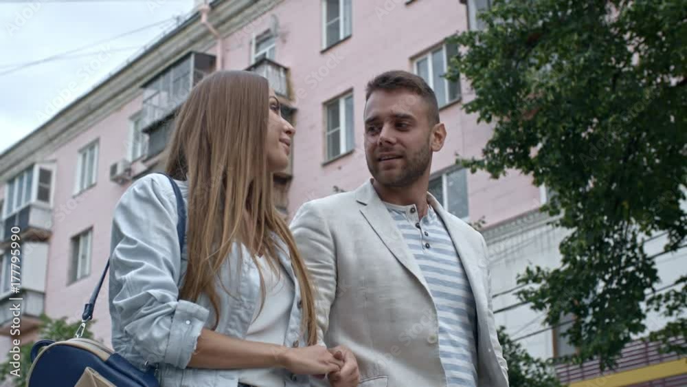 Slowmo low angled shot of beautiful loving couple walking together on outdoor date Slowmo low angled shot of beautiful loving couple walking together on outdoor date