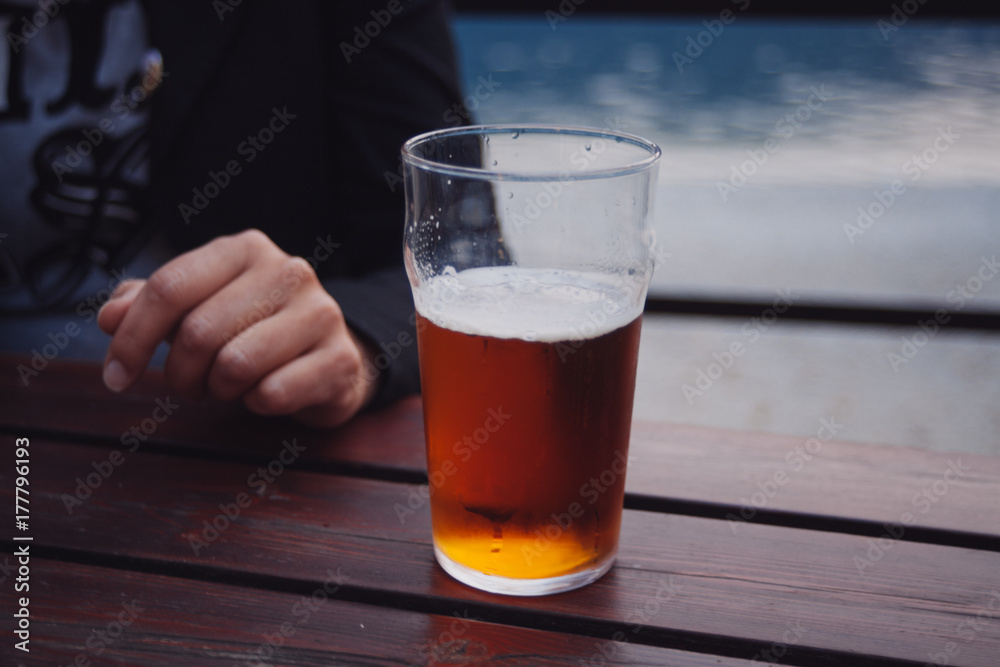 Man sitting at a table served with beer Man sitting at a table served with beer