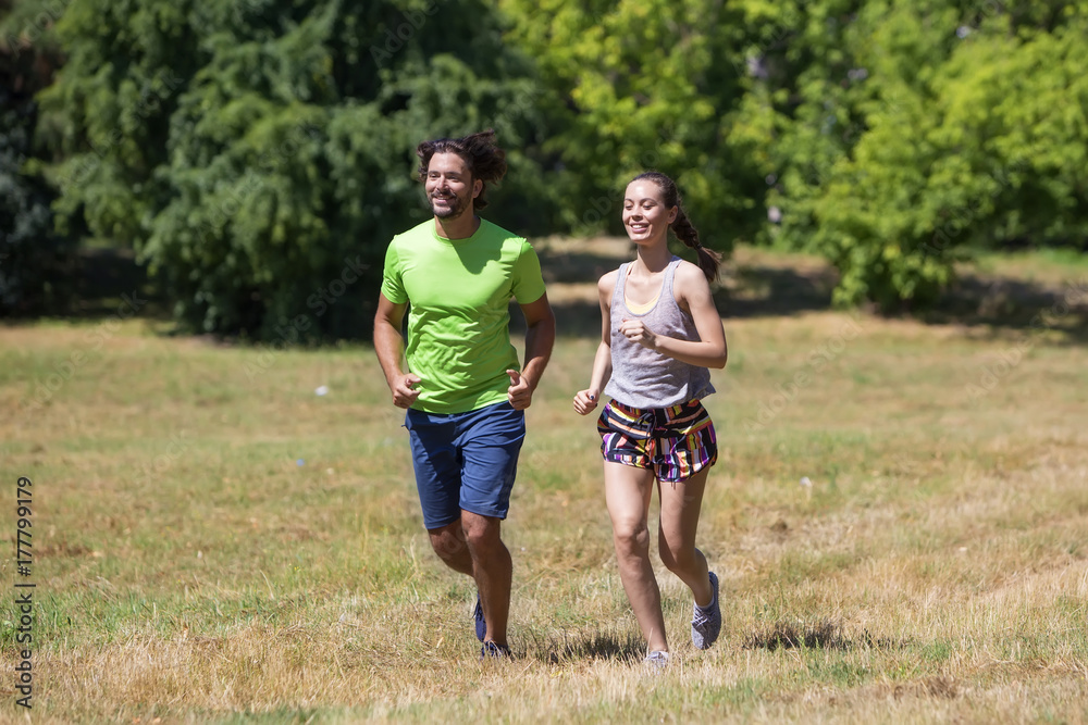 Obraz premium Healthy, fit and sportive couple running in park