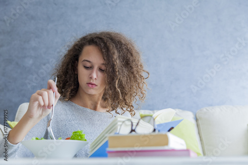 Curly hair teen girl readin...