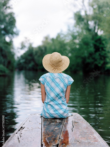 Girl wearing a hat on the front of a punt in Oxford