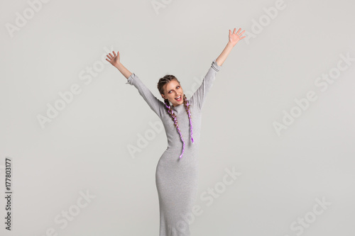 Smiling woman with braids holding hands up