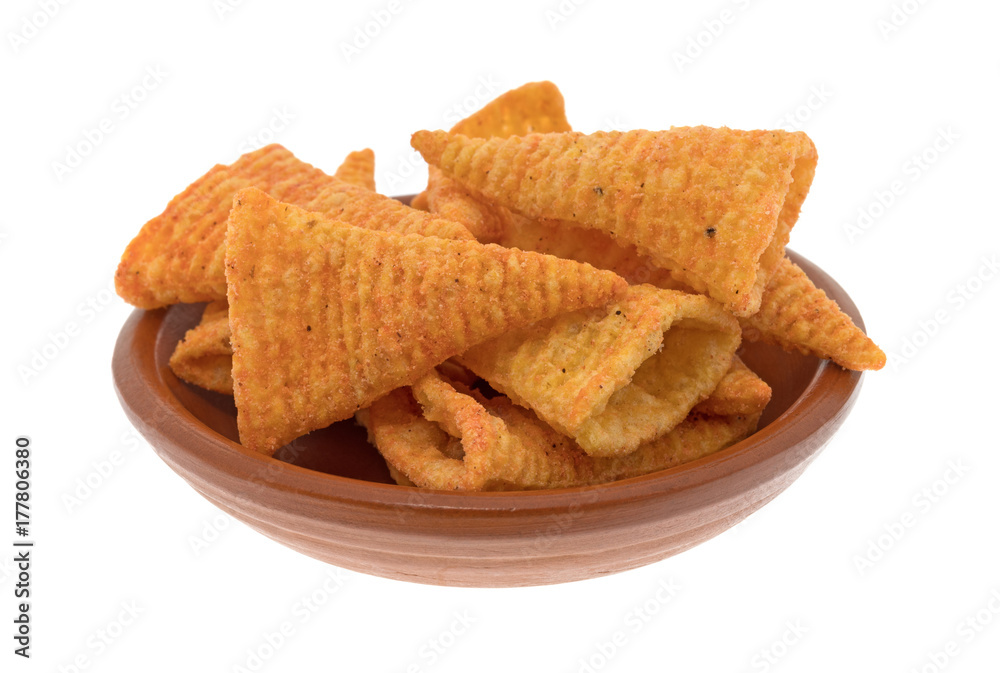 A small red clay bowl filled with cheese flavored cone shaped corn chips isolated on a white background. A small red clay bowl filled with cheese flavored cone shaped corn chips isolated on a white background.
