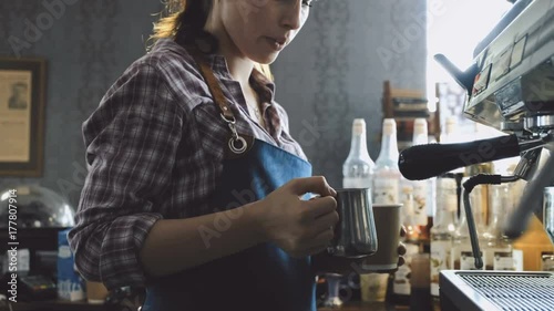 Female barista making fresh coffee on machine 