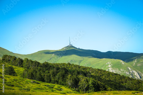 Antenna tower on the top of mountain and pine forest below. Repeater antenna tower on Zekova Glava in Montenegro photo