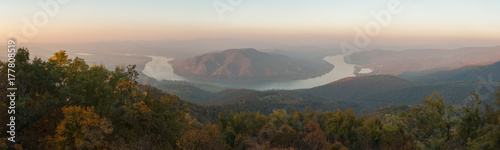view of Danube curve from Pilis mountain in october autumn landscape, misty sunset © pellephoto