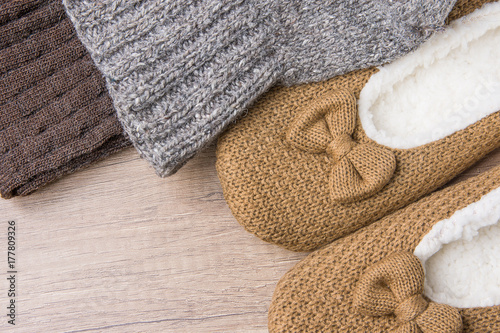 Handmade Warm Knitted Socks From Coarse Wool Yarn Fluffy Fur Slippers on Wood Background. Winter Autumn Eco Fashion Kinfolk Style. Natural Materials.