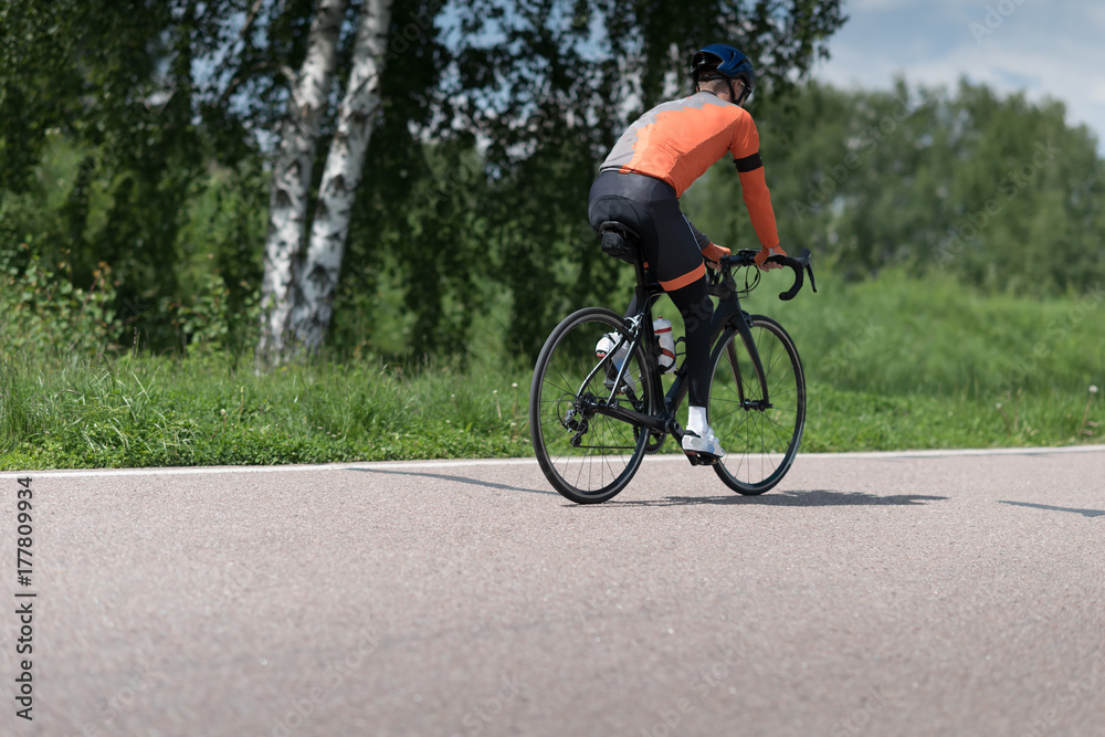 a road bike with a cyclist pedaling on a road.