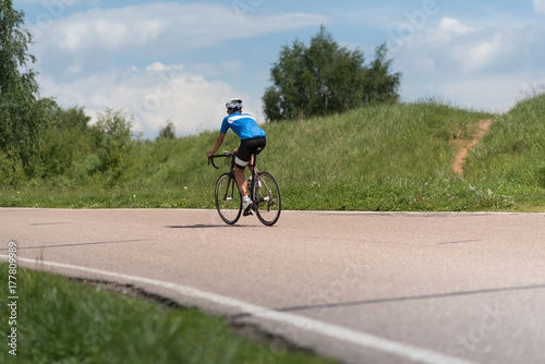 Fototapeta Naklejka Na Ścianę i Meble -  a road bike with a cyclist pedaling on a road.
