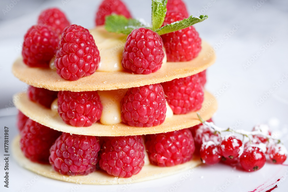 Exquisite dessert with cookies, cream and raspberries Exquisite dessert with cookies, cream and raspberries