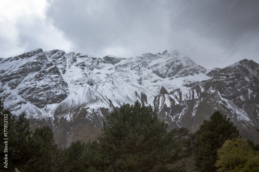 Горный пейзаж. Красивый вид на живописное ущелье, белые облака над высокими горами. Дикая природа Северного Кавказа