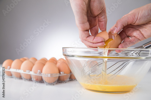 Hand beim Eier Aufschlagen in Schale für Rührei