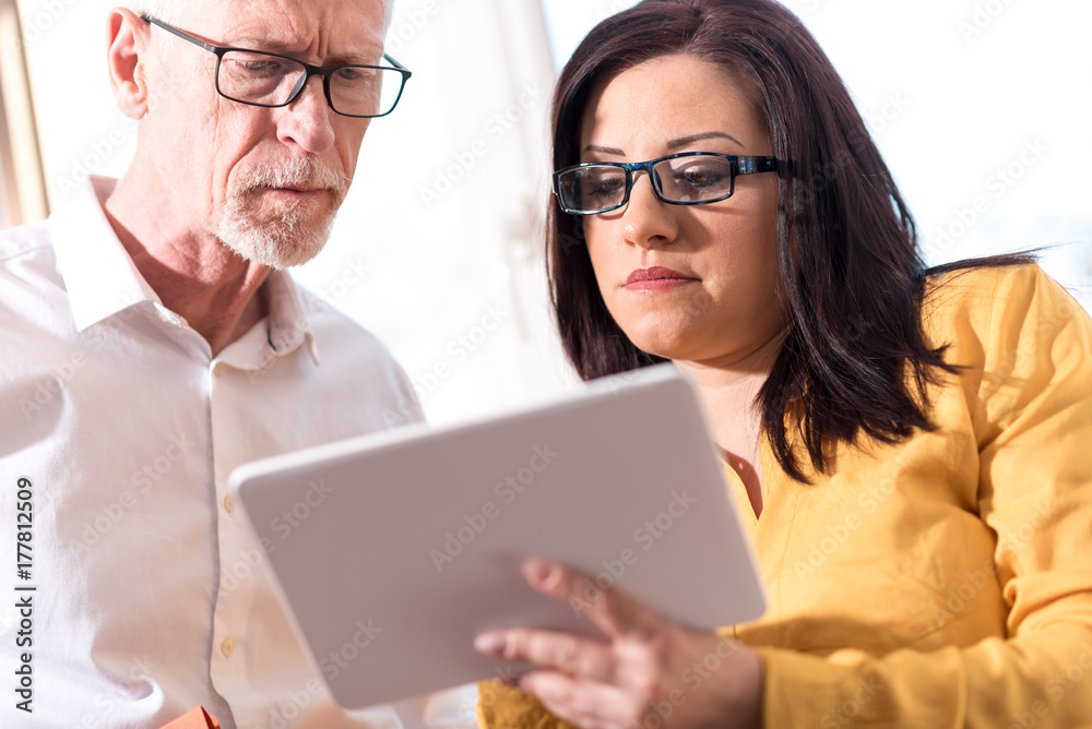 Young businesswoman and senior businessman working together Young businesswoman and senior businessman working together