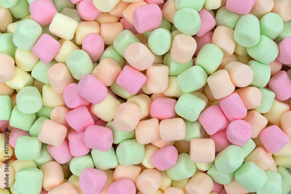 Close view of colorful pastel hued miniature green, pink, yellow and orange marshmallows. Close view of colorful pastel hued miniature green, pink, yellow and orange marshmallows.