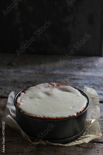 cake biscuit in split form with white cream on a woody background